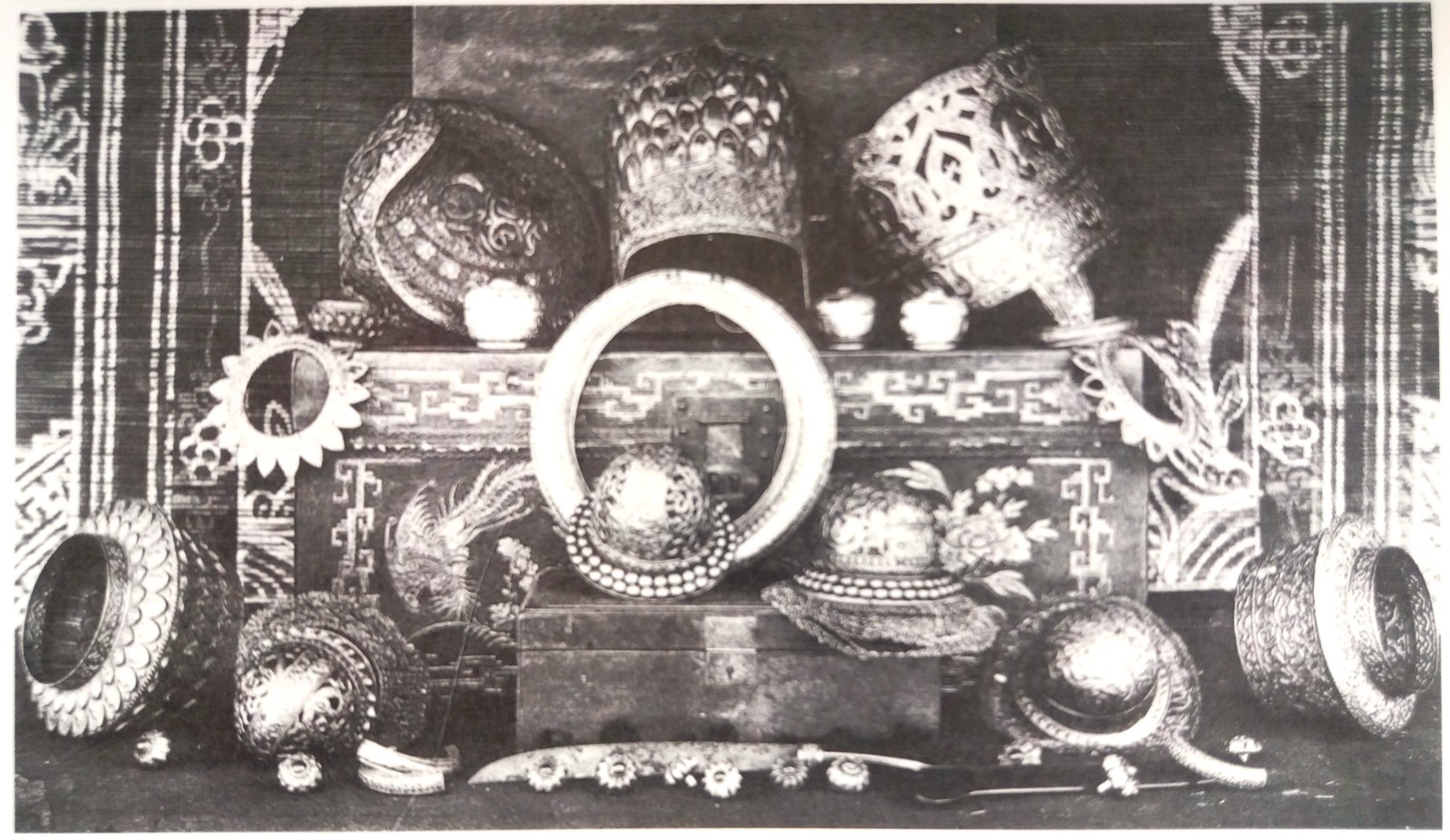An old photograph of crowns, bracelets and vessels laid out on a cloth