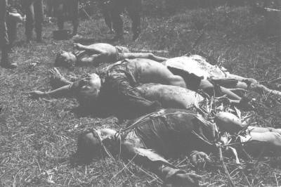 Bodies lying on the ground, one on a woven mat