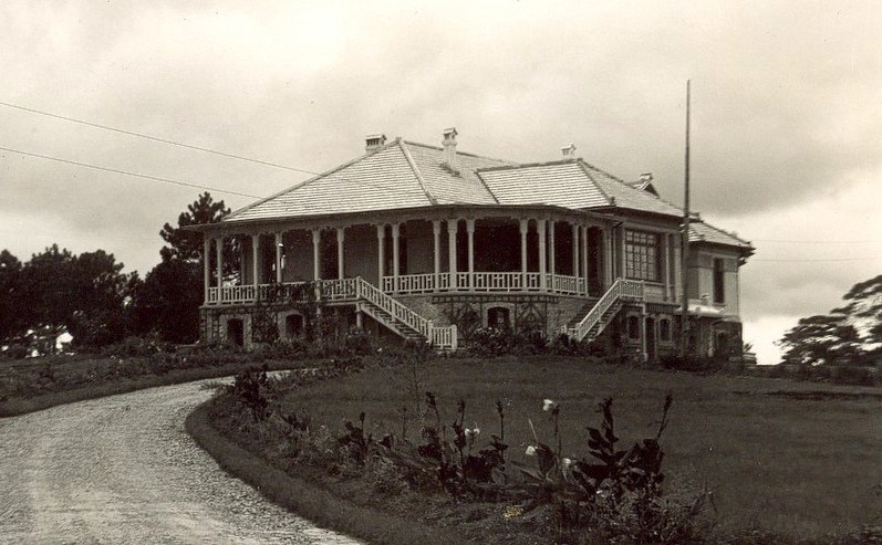 A large colonial villa with a terrace, about 1925