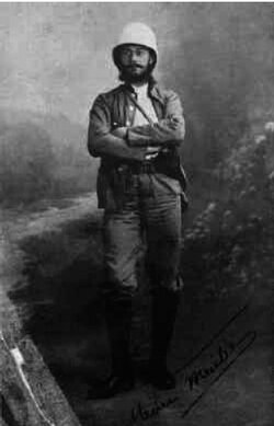 A studio portrait of a French explorer in a pith helmet