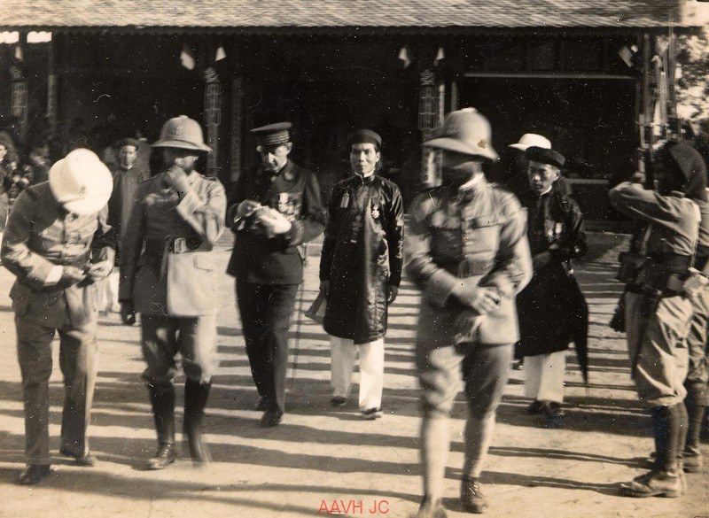 A group of Vietnamese mandarins and French officials posed in front of a building