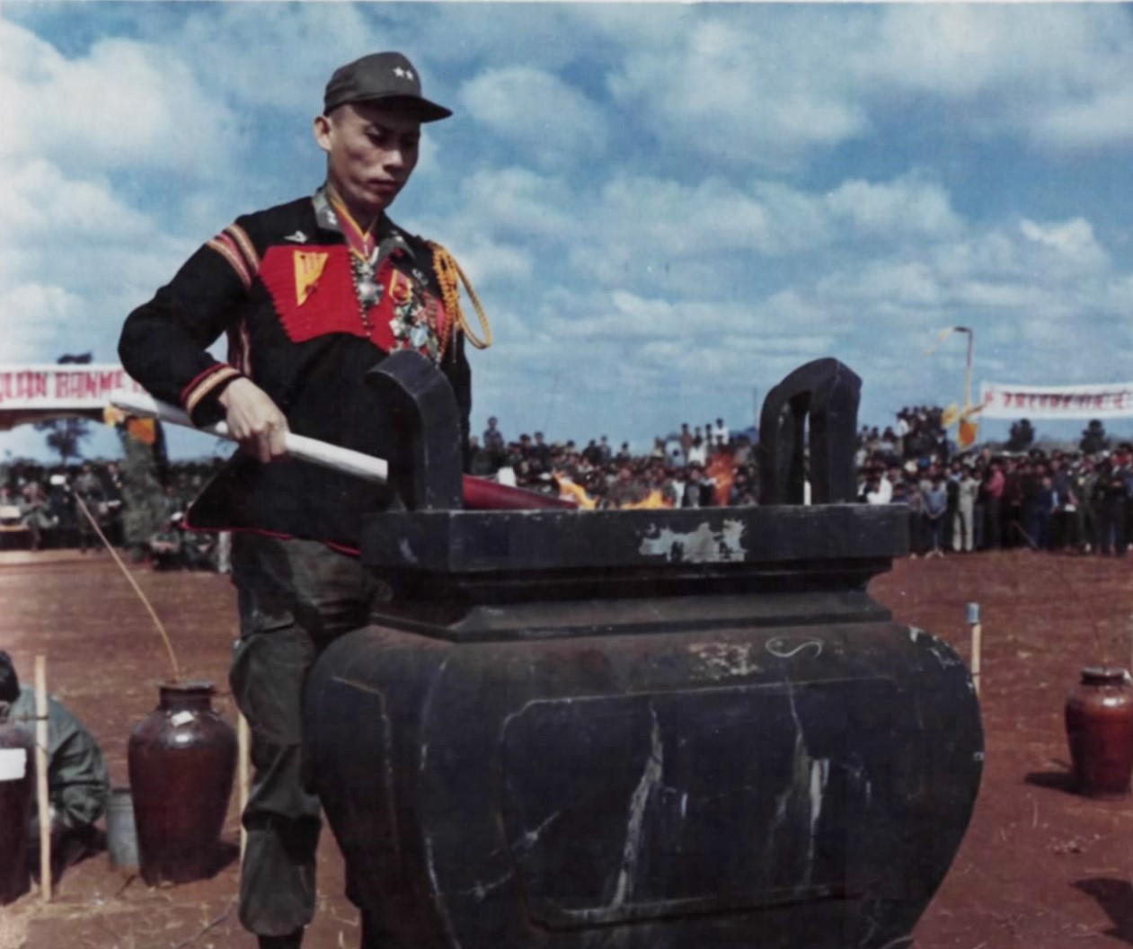 A South Vietnamese general lights a fire in a large jar-shaped altar