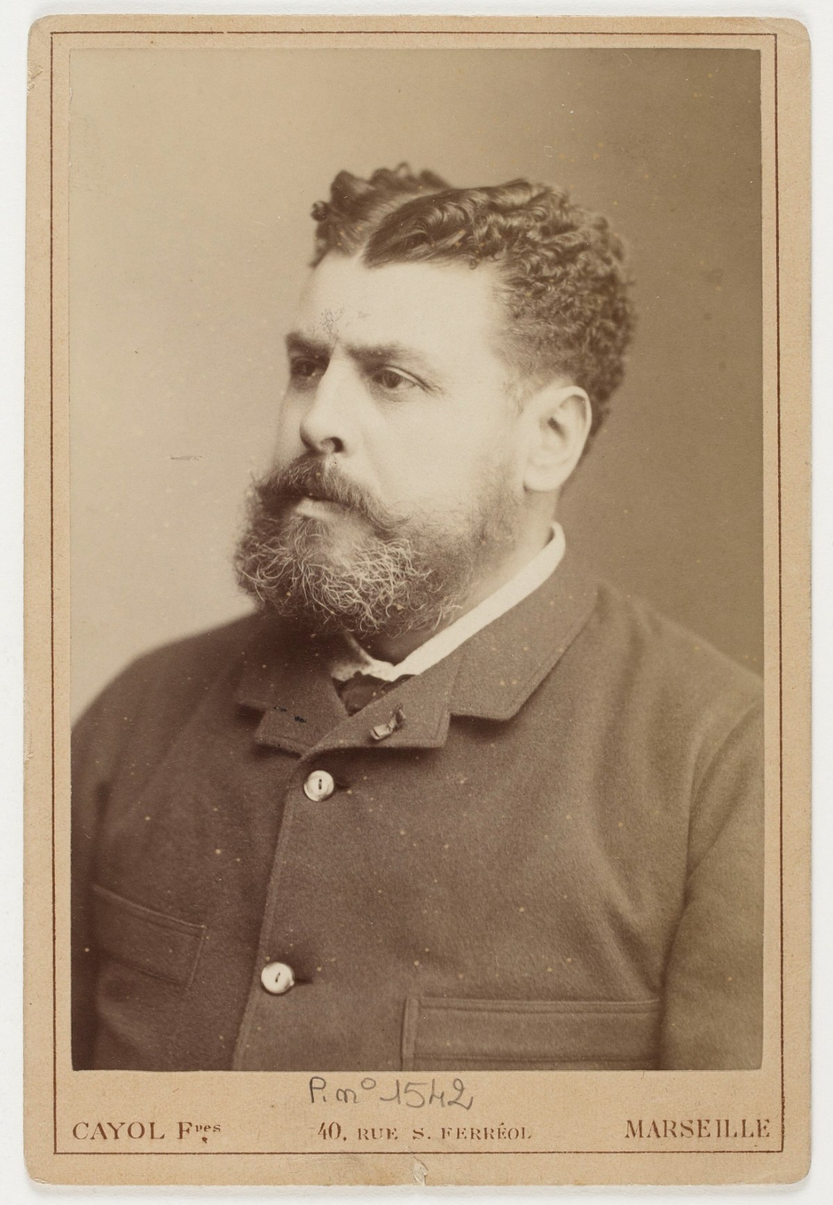 A studio photograph of a bearded man in a dark coat, 1885