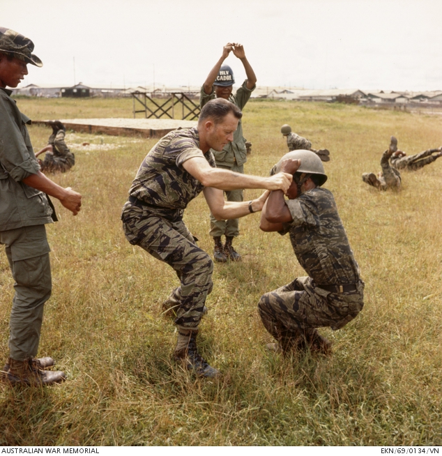 An Australian warrant officer demonstrates a parachute landing roll to a highland soldier
