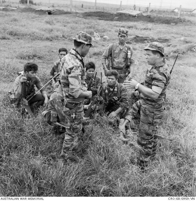 An Australian adviser instructing Montagnard soldiers in ambush drills