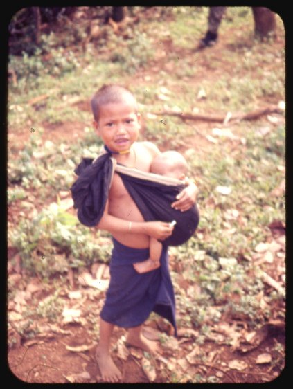 A highland girl carrying a baby on her back
