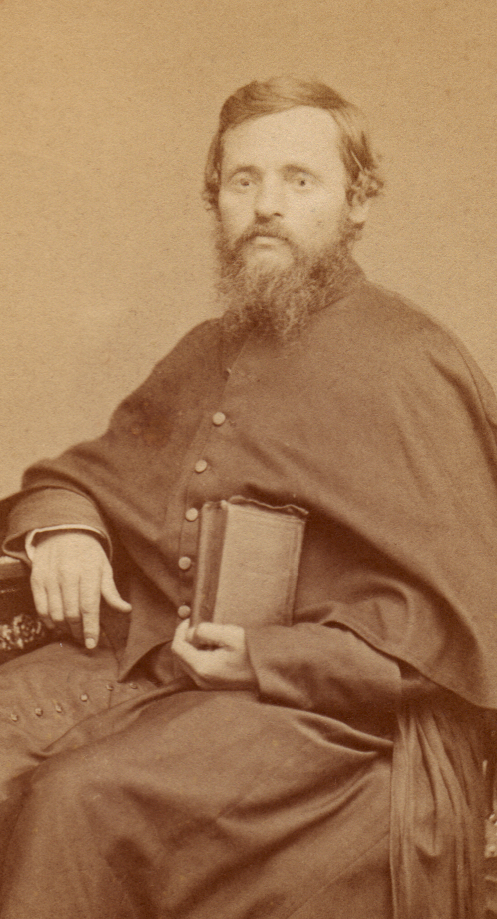 A photograph of an elderly priest with a white beard
