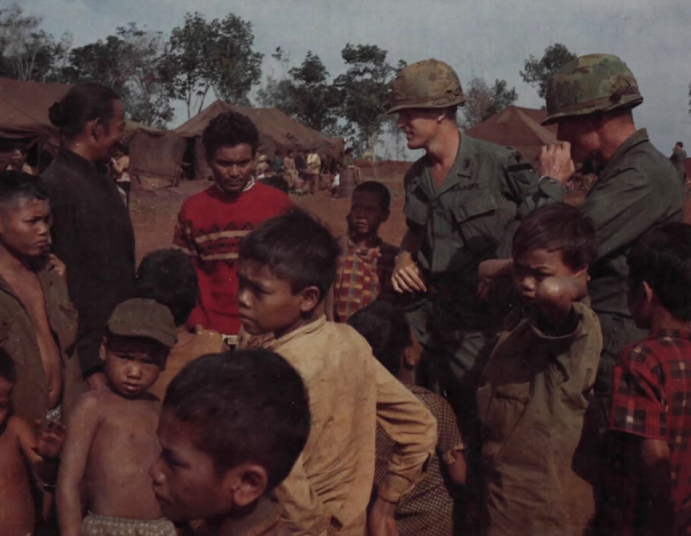 American soldiers talking with a crowd of highland children and adults