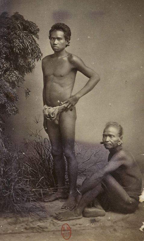 Two Stieng men photographed in the nineteenth century, one standing and one seated