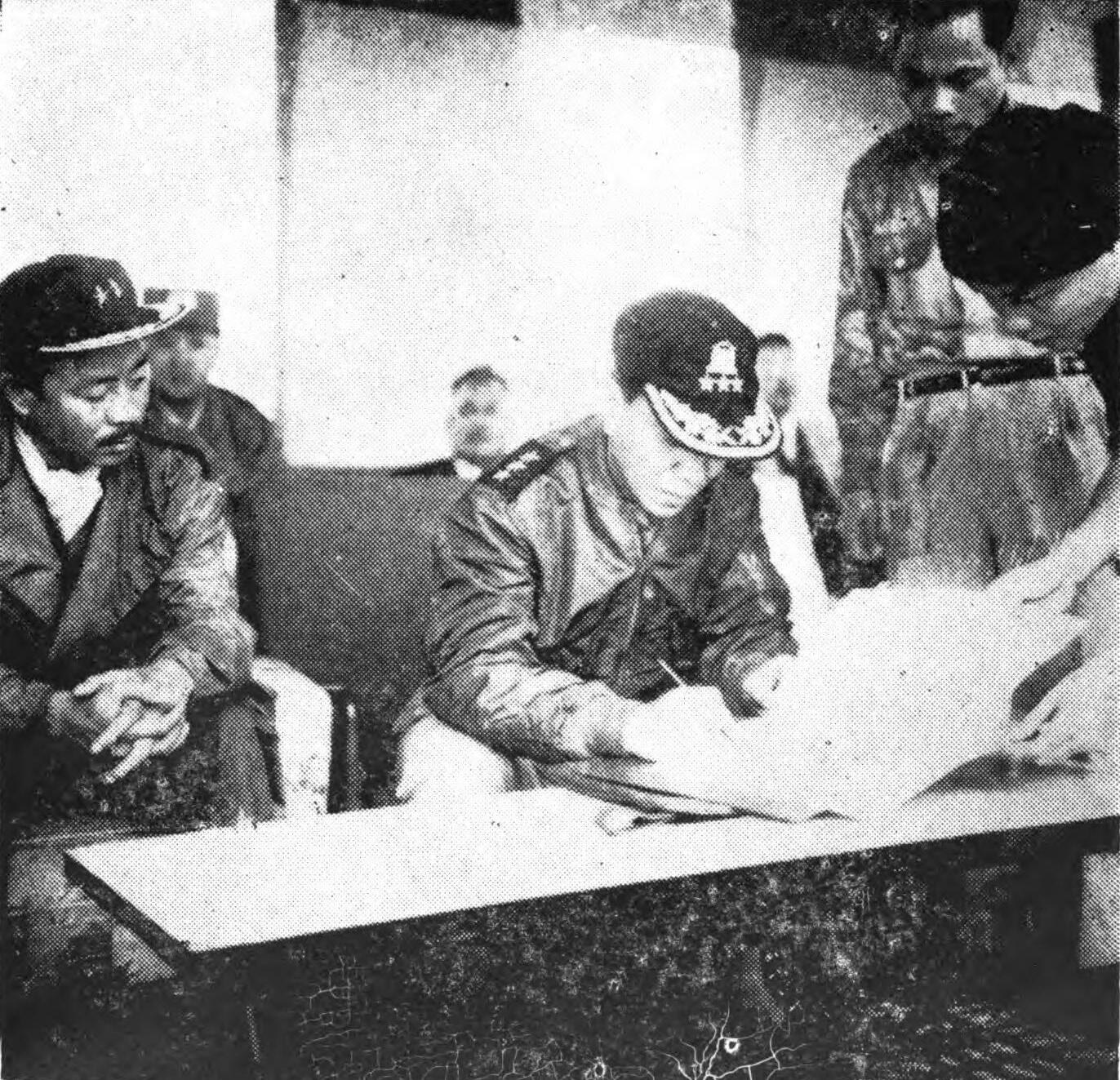 A president signing a document at a table with officials and highland leaders around him