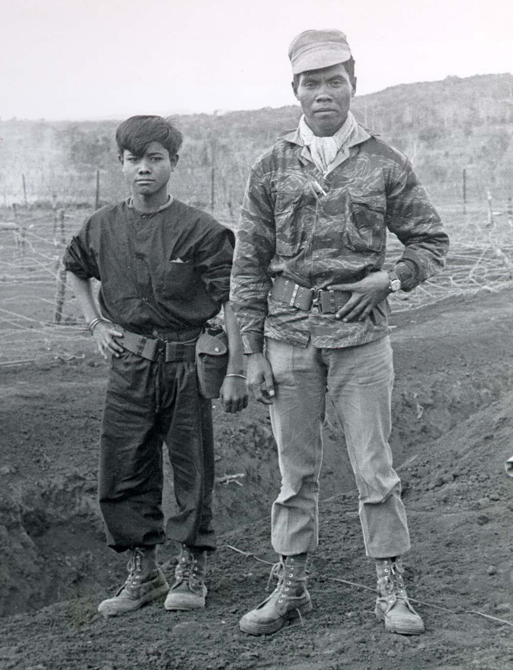 Two Dega fighters standing in a cleared field, one in camouflage