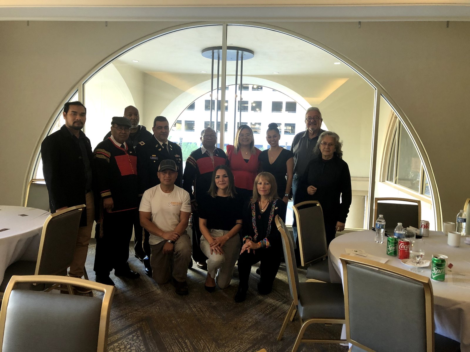 The Dega delegation and conference attendees gathered for a group photograph in front of a tall arched window