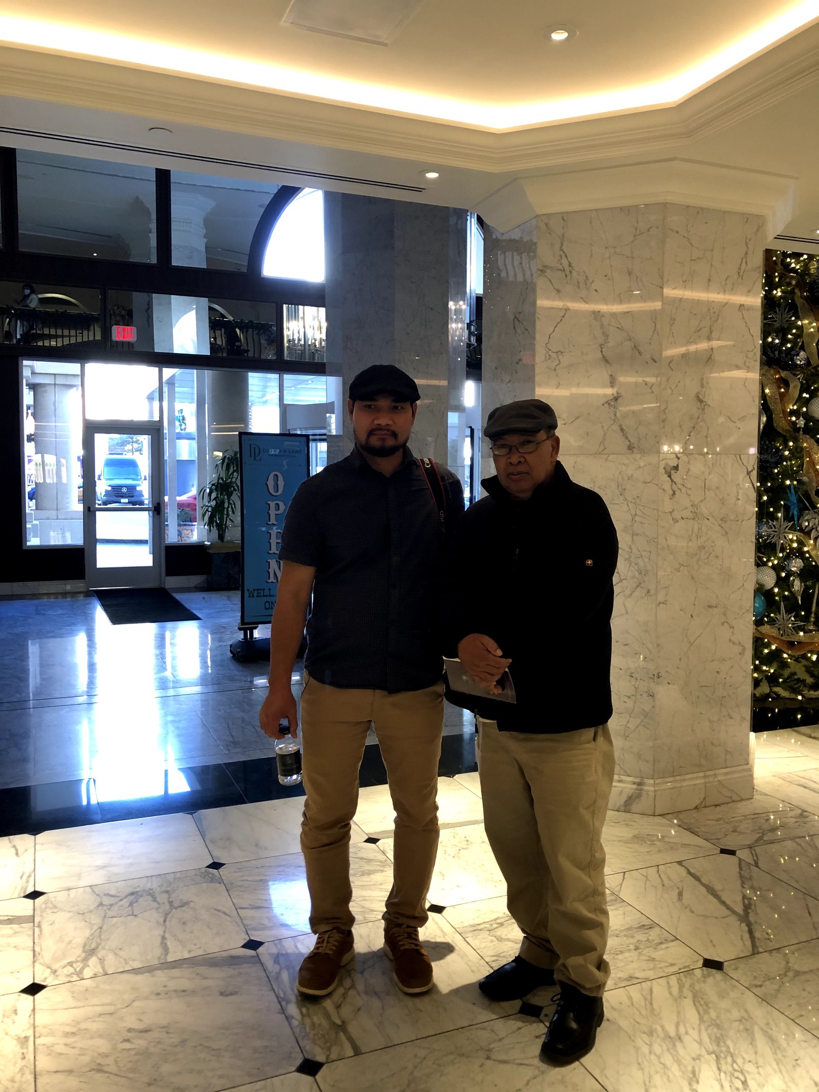 Two Dega delegates standing together in the hotel lobby, one holding a document