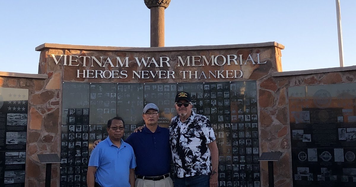 Three men at the Vietnam War Memorial in Las Cruces, New Mexico, beneath the words Heroes Never Thanked