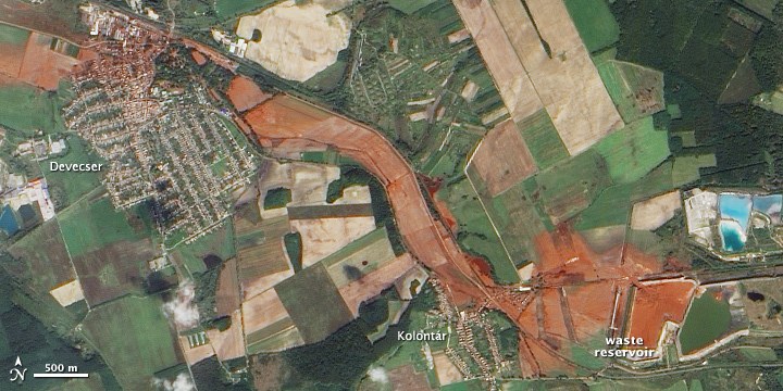 A satellite image of farmland with a red streak running from a reservoir west through two villages