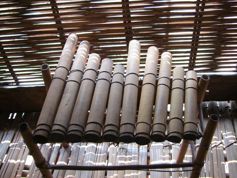 A row of bamboo tubes of different lengths laid on a wooden frame