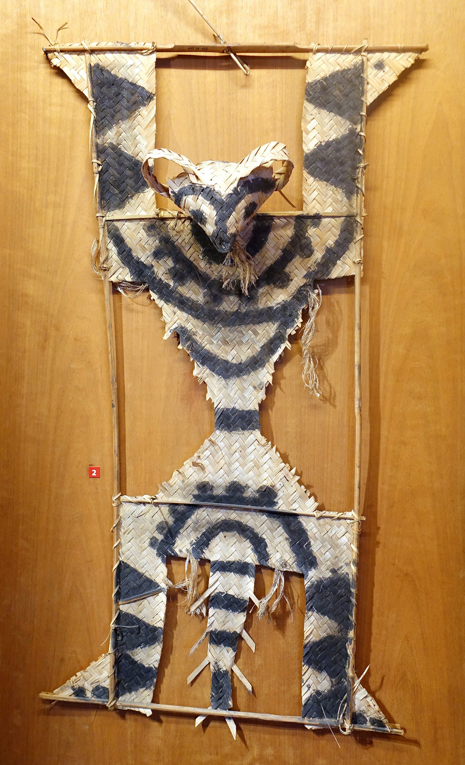 A tall figure of woven bamboo in the shape of a monkey, made to stand in a field