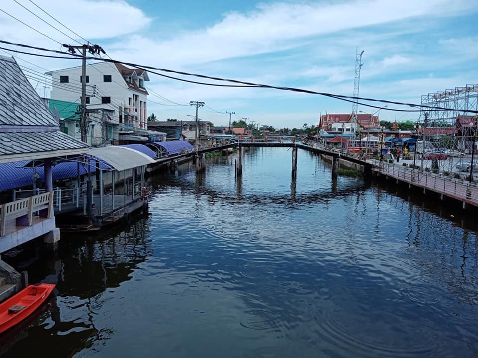 A canal lined with houses on stilts and a small bridge