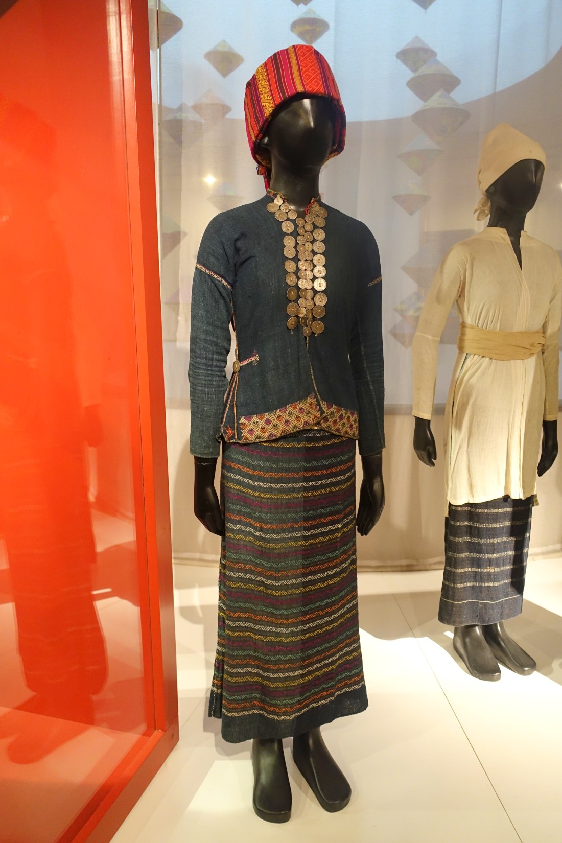 A woman’s costume of dark cloth hung with rows of old coins