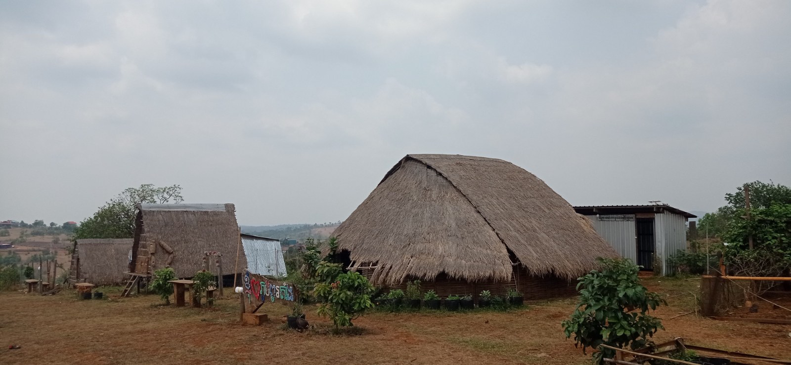 A long low house with a thatched roof reaching almost to the ground