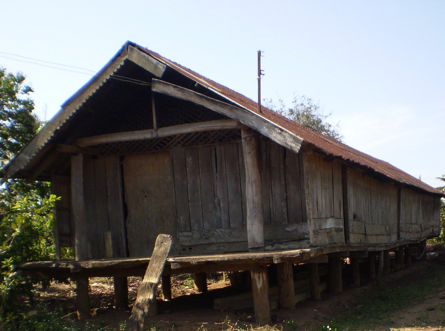 A long thatched house on tall wooden piles