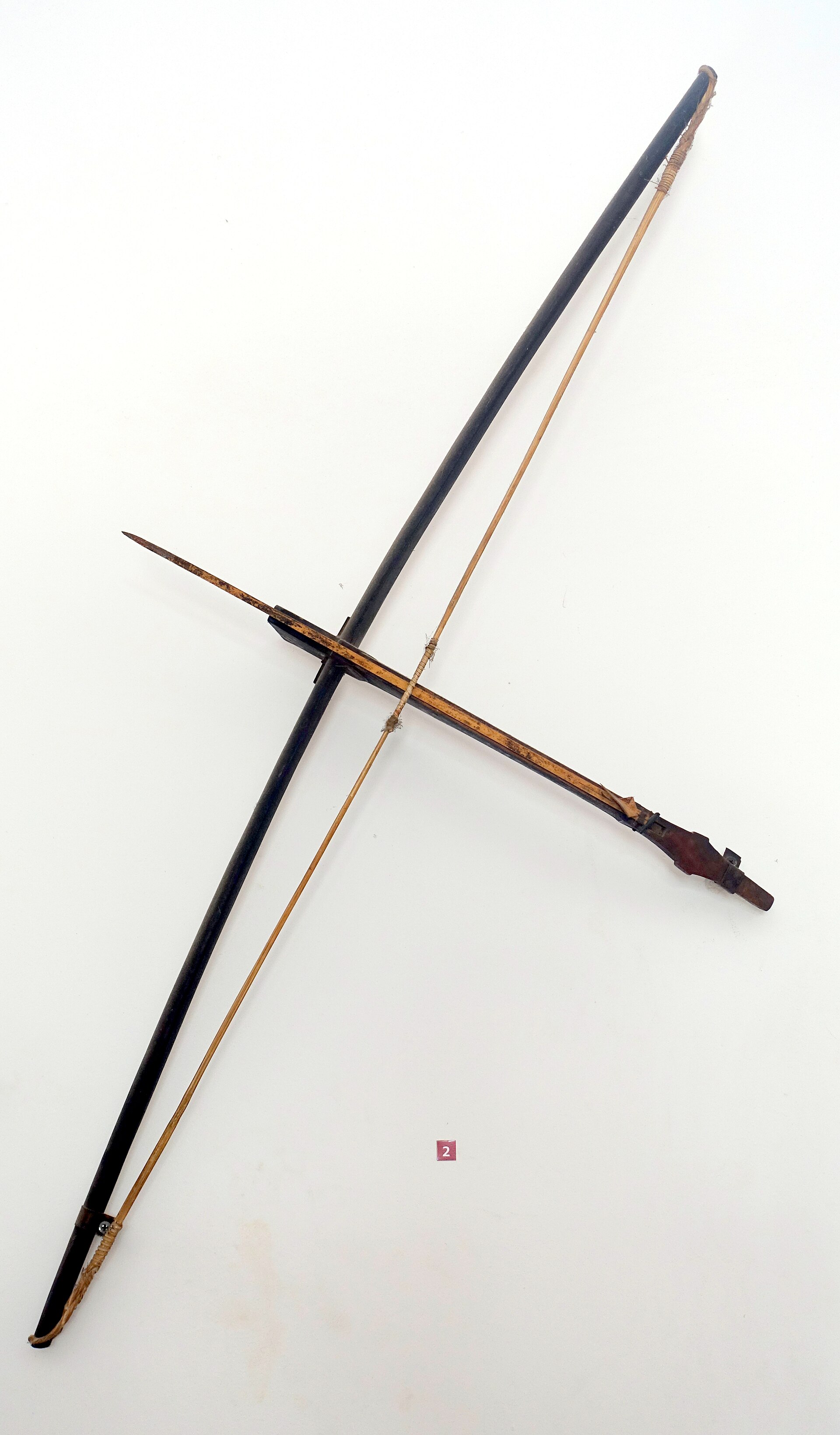 A wooden crossbow with a long bamboo bow and a thin arrow