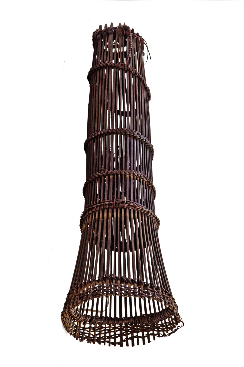 A tall conical fish trap woven of bamboo