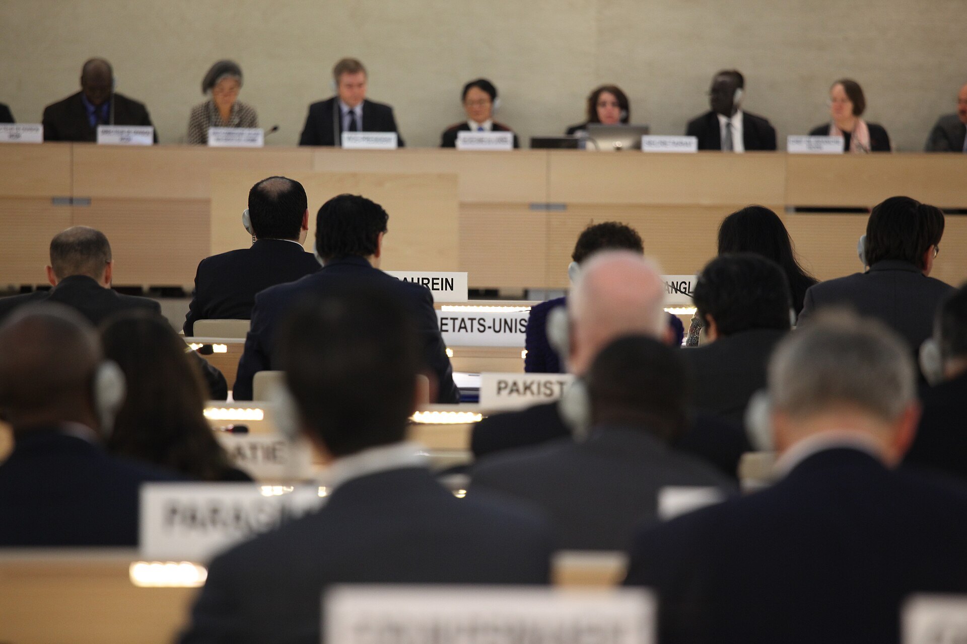 Delegates seated in rows at a session of the UN Human Rights Council, seen from behind