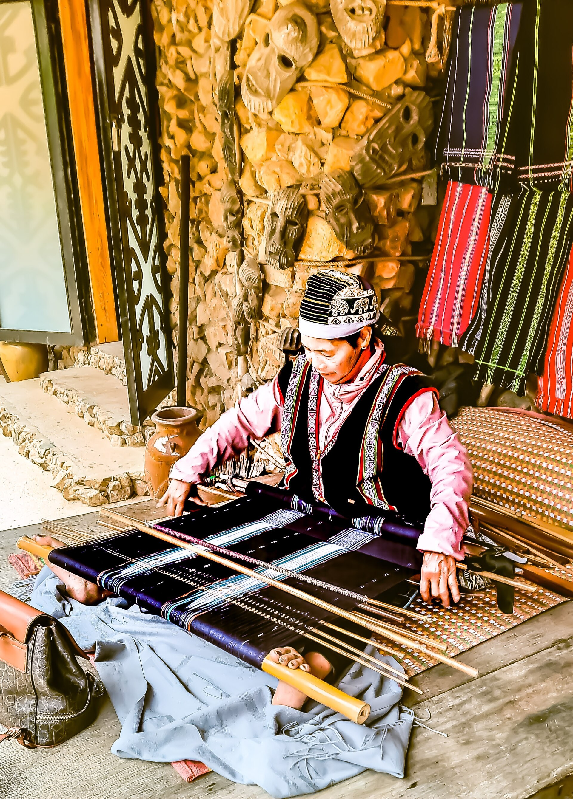 A Koho woman weaving on a backstrap loom