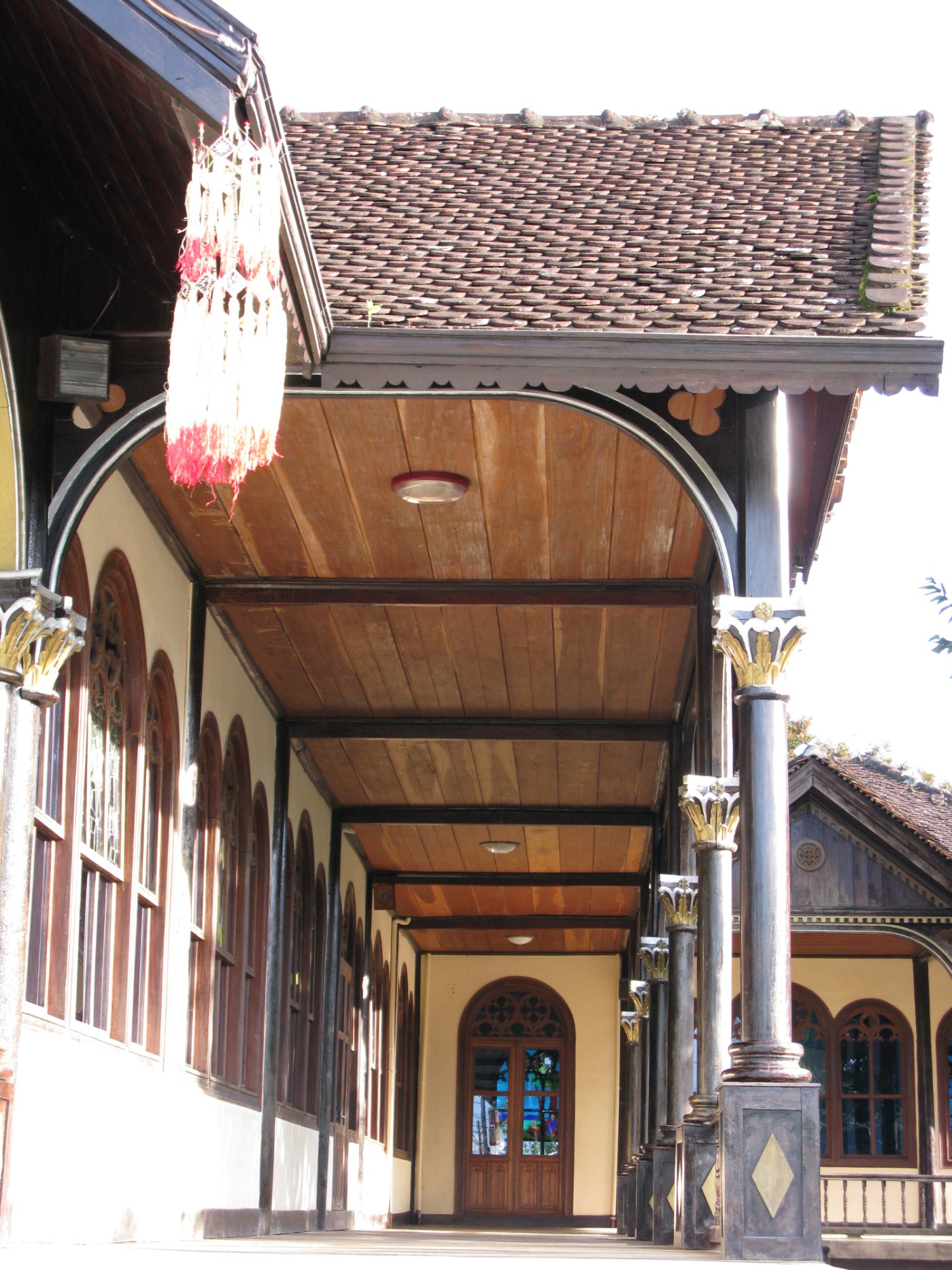 A wooden church with a tall steeple on a sunny day