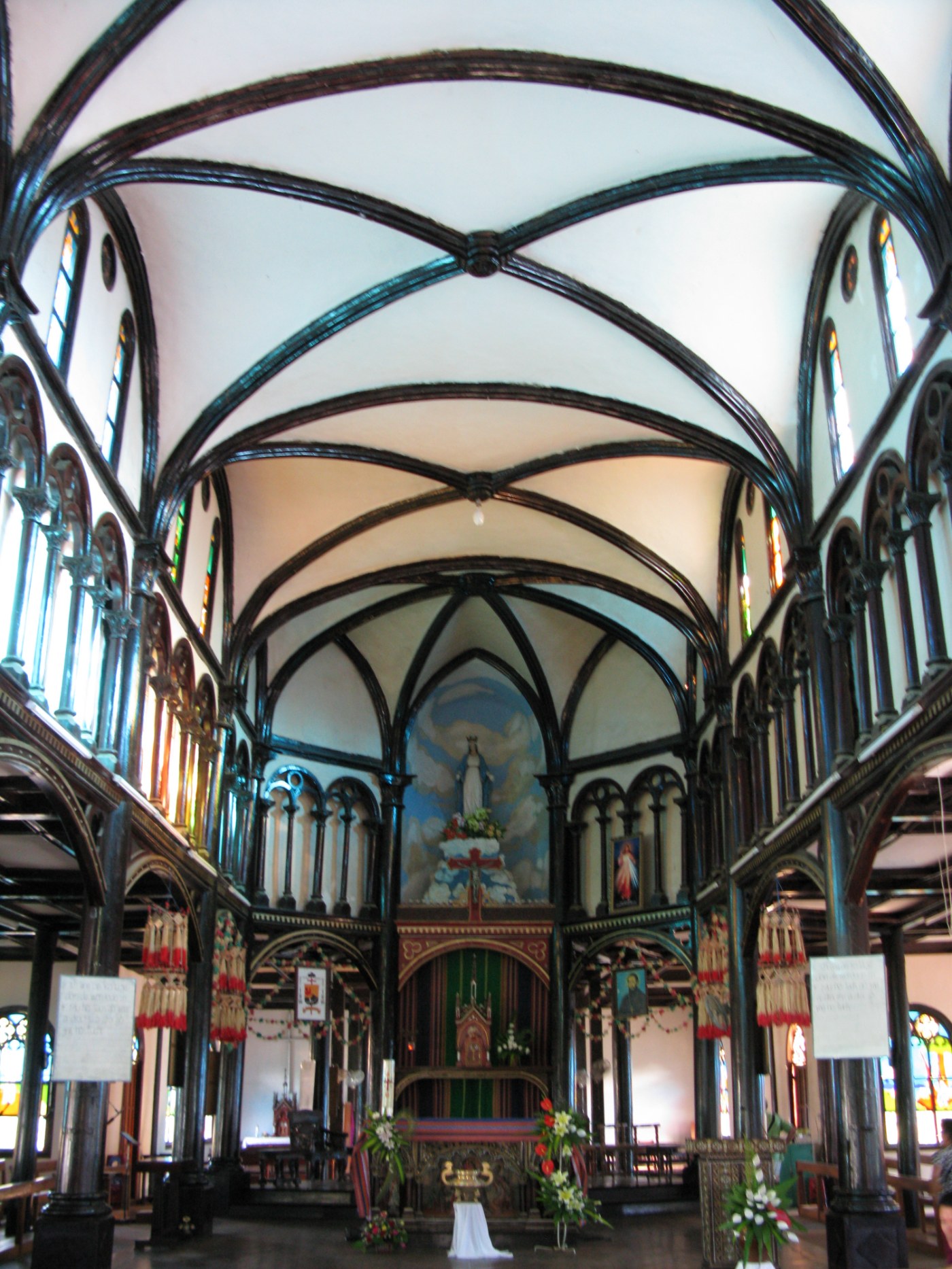The wooden interior of a church, with columns and a high roof