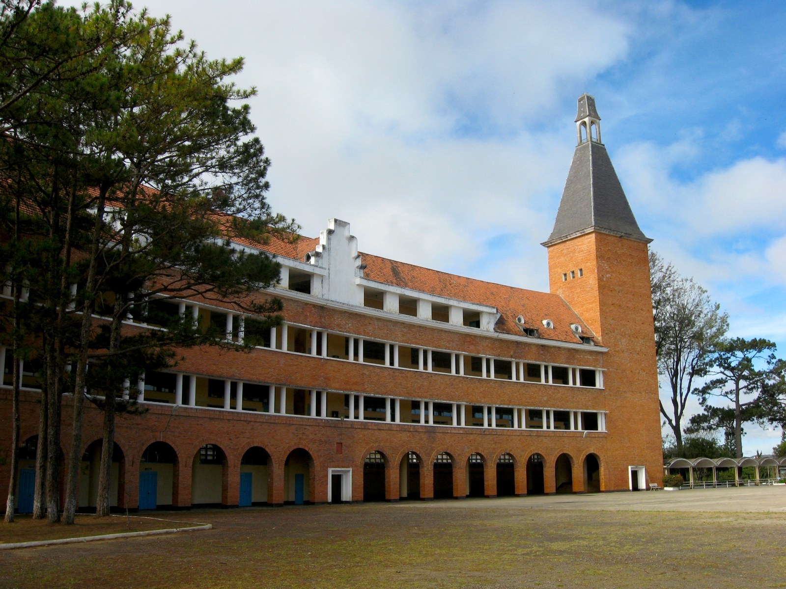 A curved brick school building with a tall tower