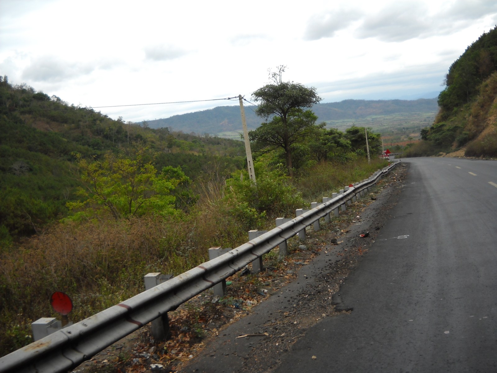 A road winding over a green mountain pass