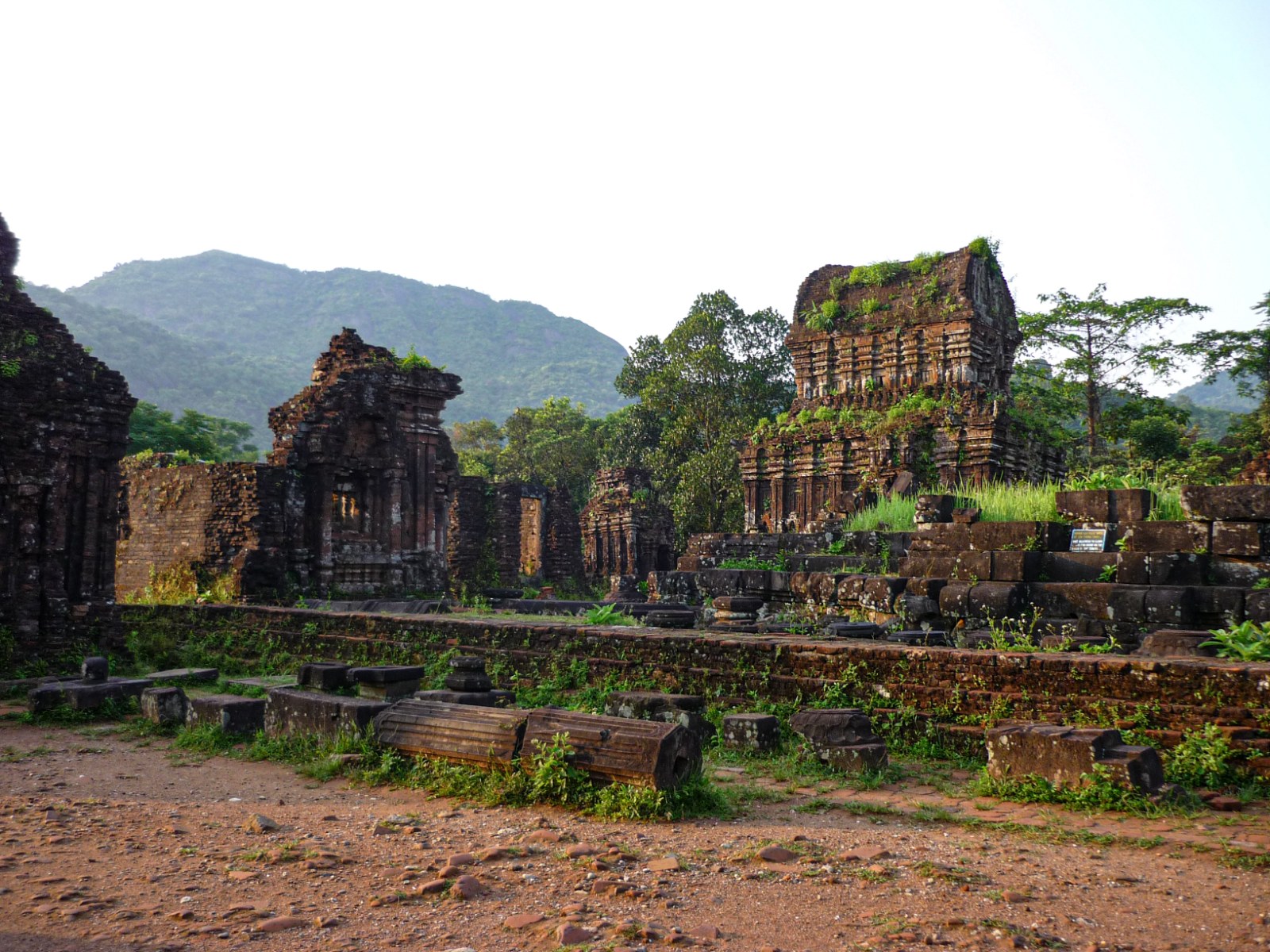 Ruined brick temples among trees in a green valley