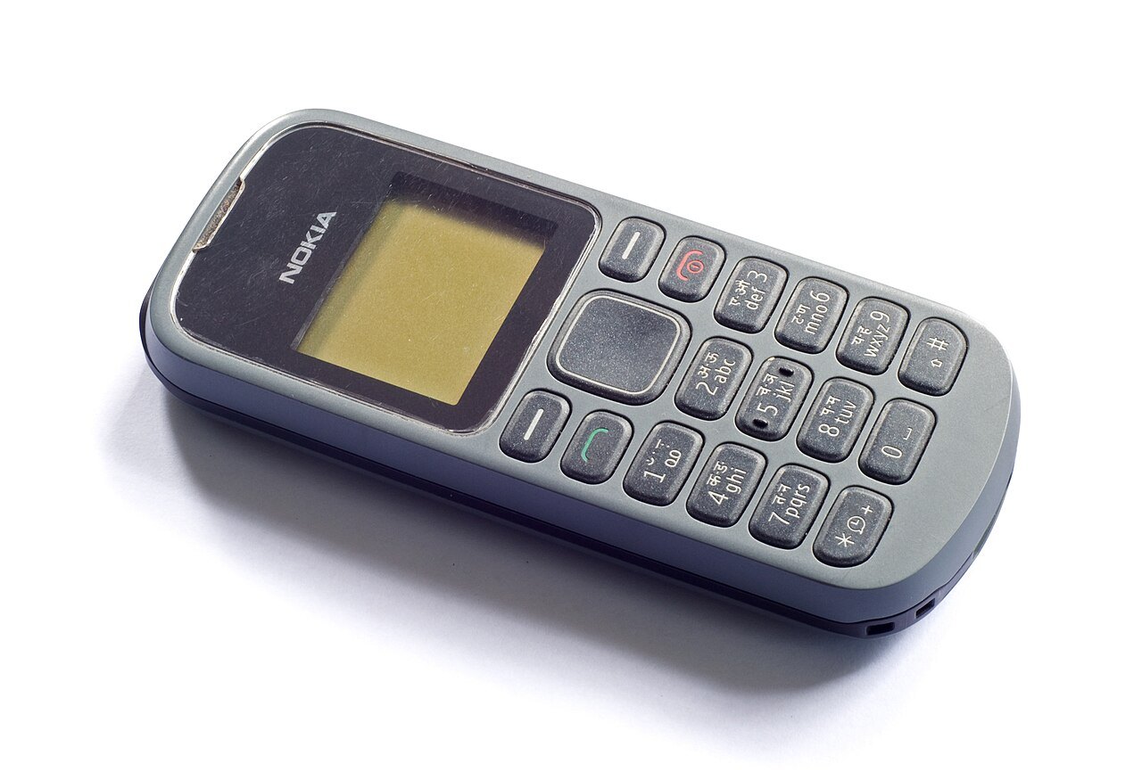 A small gray push-button mobile phone with a monochrome screen