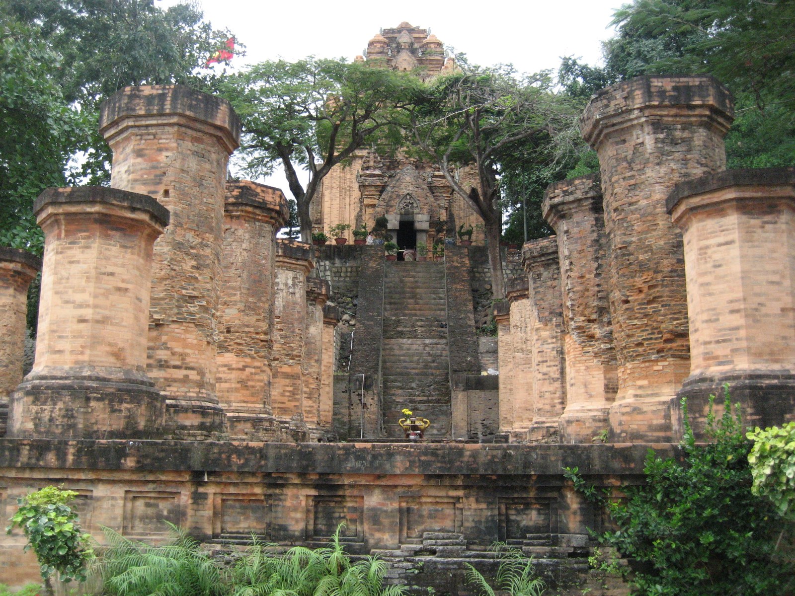 A tall brick Cham tower with carved doorway seen from below