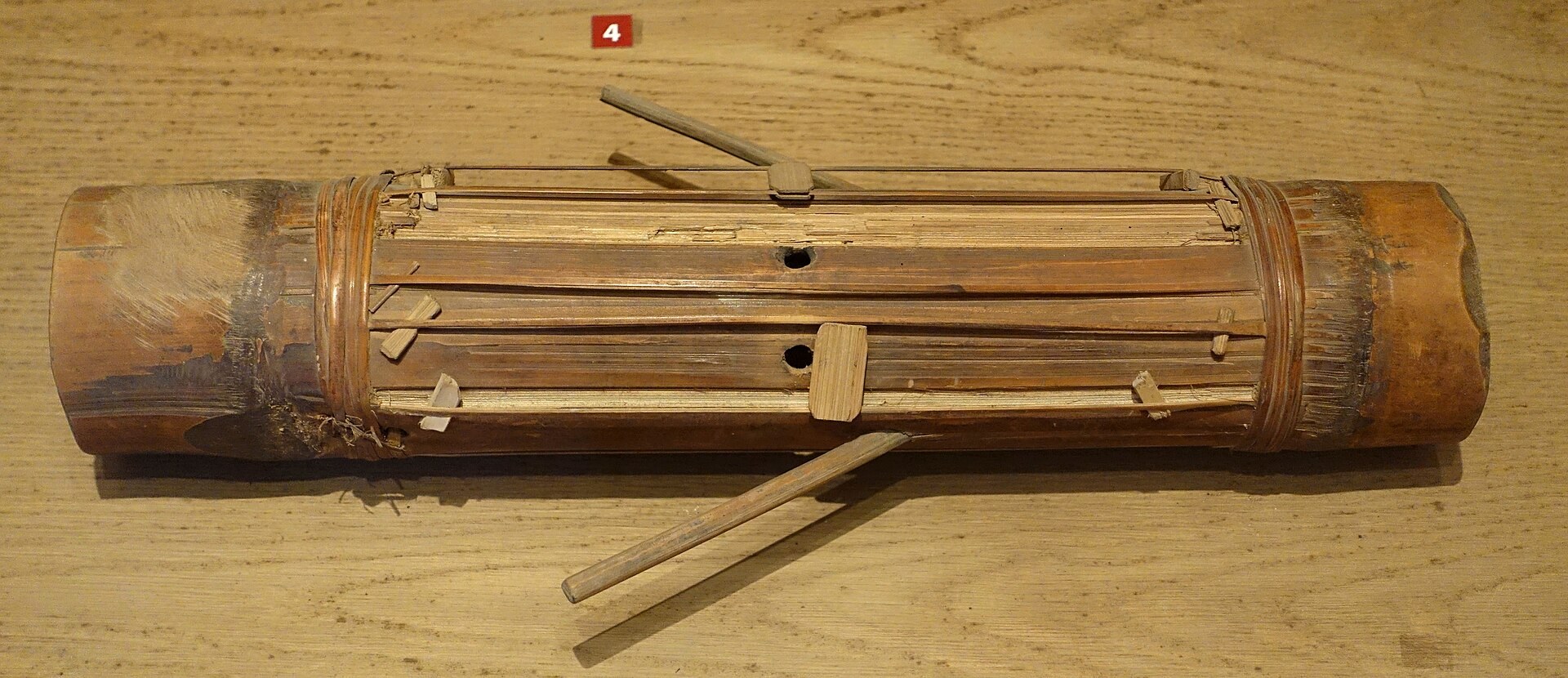 A bamboo tube zither with raised strings cut from its own skin