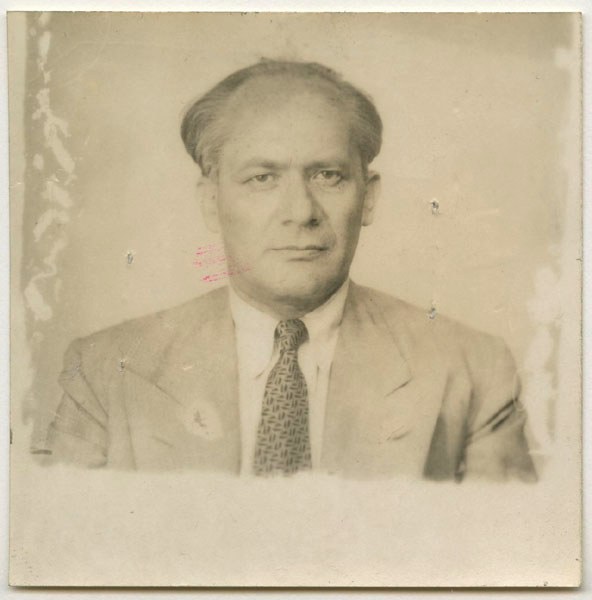 A black and white portrait of a middle-aged man in a suit and tie