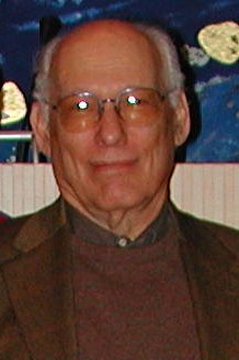 A portrait of an older man with glasses and white hair