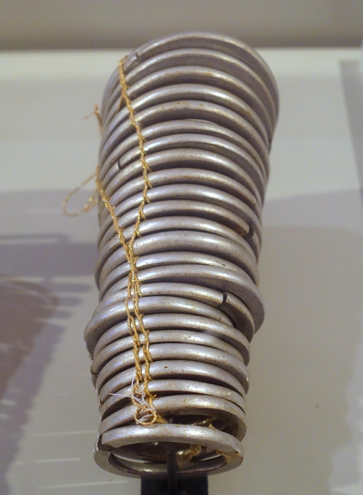 A stack of many thin metal bracelets on a stand