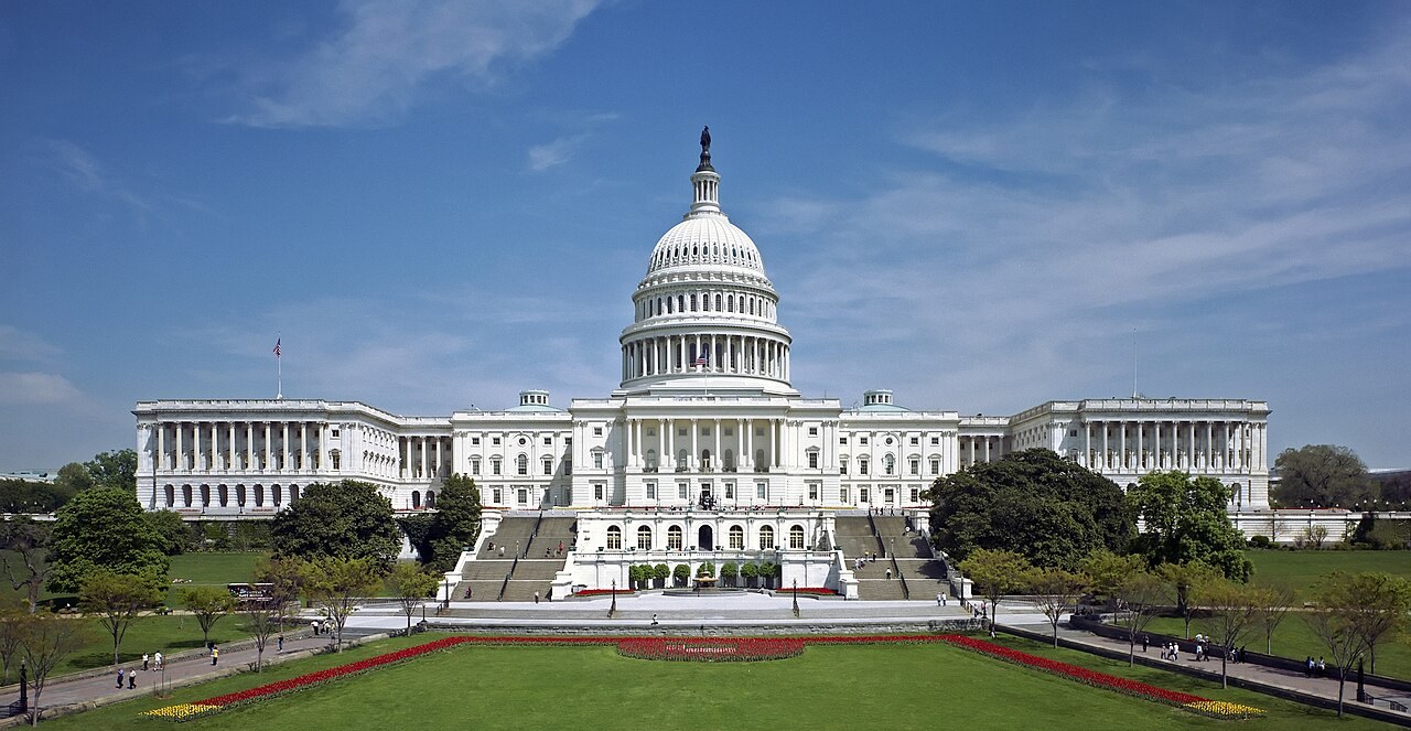 The west front of the United States Capitol with its dome, seen across a lawn