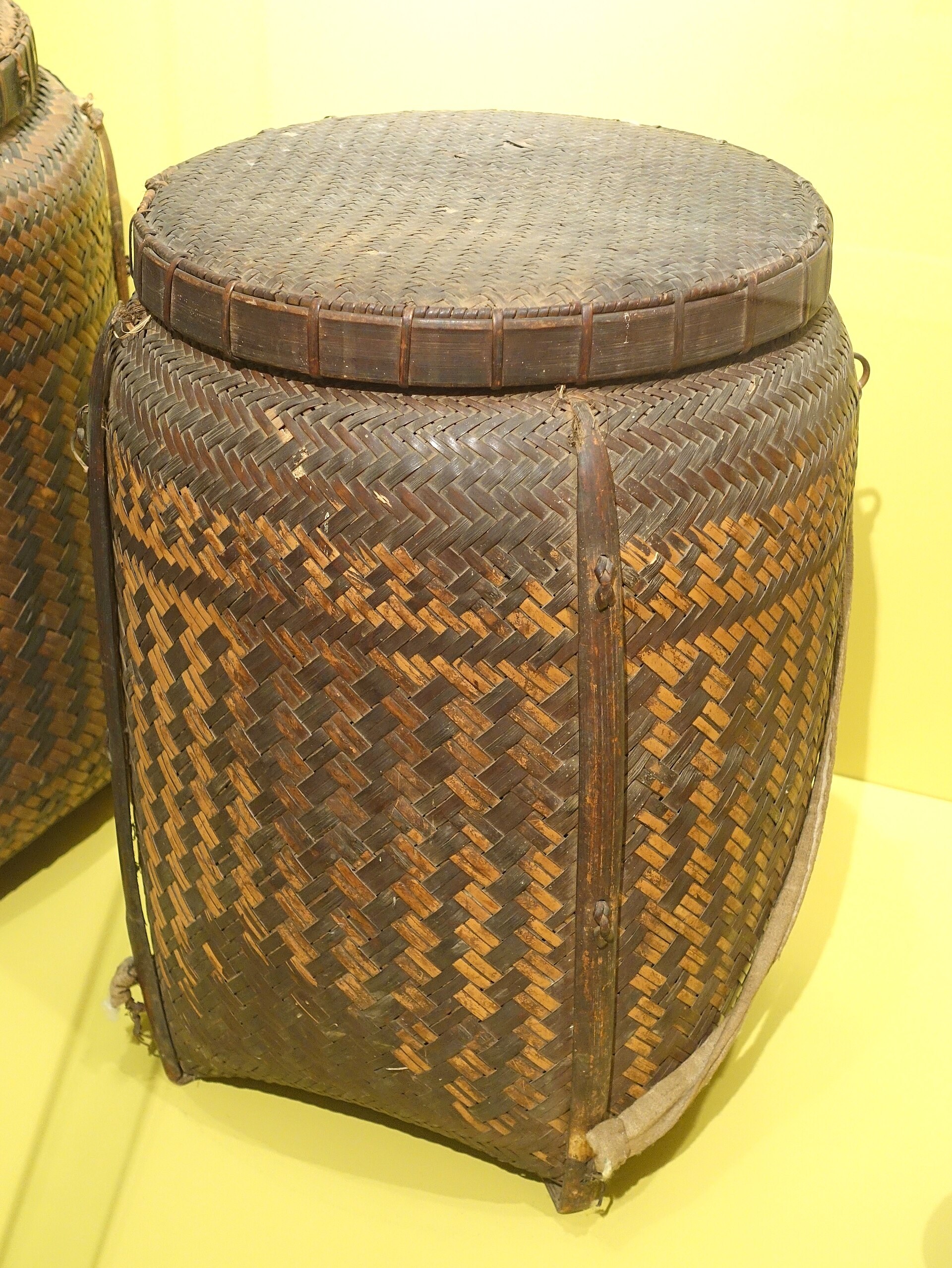 A very large woven storage basket, taller than a person, for keeping rice