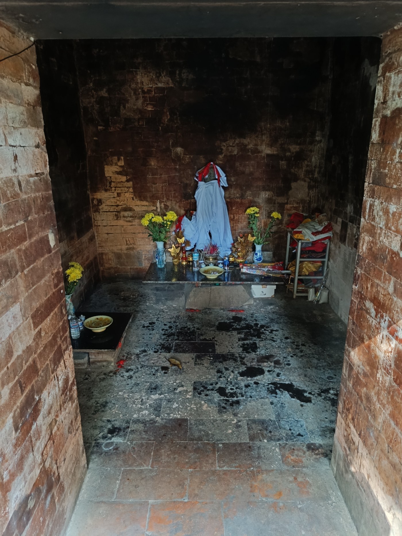 The brick doorway of a Cham tower with offerings on a stone inside